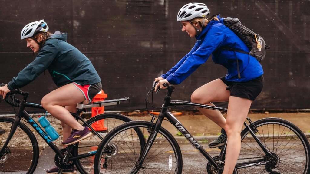 Women cyclists enjoying a rainy day ride with helmets and gear.